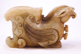 An Asian carved jade Libation cup in the form of a resting griffin,