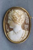 A yellow metal oval carved cameo brooch. Base metal pin and revolver fitting.