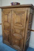 An 18th century Continental armoire, with two multi panelled doors on strap hinges,