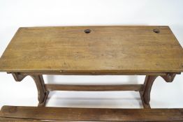 A child's double school desk, the sloping top with two recesses for inkwells,