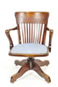 A mixed hardwood tilt/swivel/raising Captain's chair with deep back top rail over squared back rods