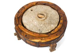 An Indian teak and metal grindstone,