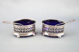 A pair of silver salts, of oval pierced Georgian form, raised on four bun feet, Birmingham 1922,