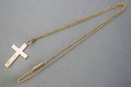 A yellow metal cross pendant (hallmarked 9ct gold) suspended from a trace link chain (stamped 15ct)