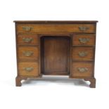 A George III style mahogany kneehole desk with one long drawer above three drawers to either side,