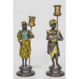 Two cold painted metal figural candlesticks in the form of a male and female Moor, in exotic dress,