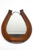 An oak horseshoe framed wall mirror, decorated with nail heads,