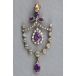 A yellow and white metal abstract pendant set with amethyst, peridot, diamonds and seed pearls.