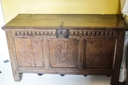 A 17th century oak coffer with triple panelled front and carved frieze,