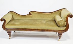 A mahogany double scroll end asymmetric late Regency sofa with back rail and worked front raised on
