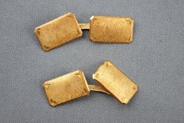 A yellow metal pair of rectangular cufflinks. Bar fitting with textured finish.