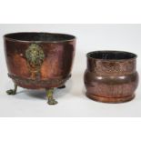 A copper coal bucket with brass lion mask ring handles and brass lion paw feet,