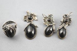 A white metal jewellery suite consisting of a ring, pendant and earrings,