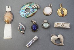 A collection of ten yellow or white metal pendants of variable designs.