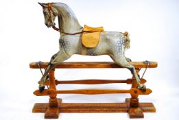 An early 20th Century carved and painted rocking horse by F H Ayres, with ivorine Hamleys lable,