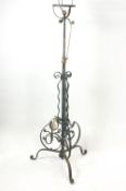 A wrought iron standard lamp with scroll and foliate detail,