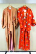 Two 20th century Kimonos and an Obi, both printed on orange grounds,