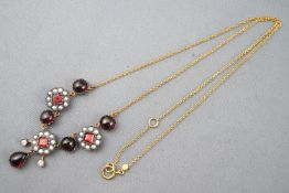 A yellow and white metal centrepiece necklace set with cabochon and faceted cut garnets