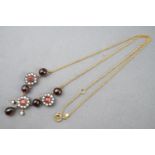 A yellow and white metal centrepiece necklace set with cabochon and faceted cut garnets