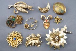 A collection of twenty base metal costume brooches of variable designs.