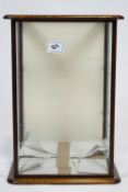 A square form glazed mahogany show case, with solid panel door on a plain base,