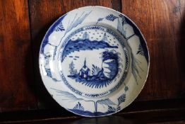 An 18th century English Delft plate, painted with landscape,