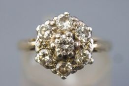 A yellow and white metal cluster ring set with seven round brilliant cut diamonds.