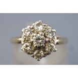 A yellow and white metal cluster ring set with seven round brilliant cut diamonds.