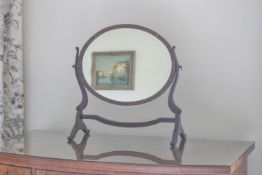 An oval mahogany swing frame mirror,
