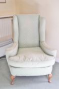 A wing armchair on cabriole legs,