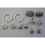 A collection of six pairs of white metal earrings consisting of drops,