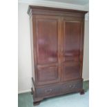 A mahogany wardrobe with two chamfered panels above two drawers on ogee bracket feet,