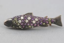 A yellow and white metal fish brooch. Grain set with amethyst, peridot and round cut diamonds.
