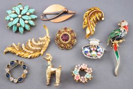 A collection of twenty base metal costume brooches of variable design.