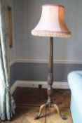 A mahogany standard lamp on cabriole legs with ball and claw feet,