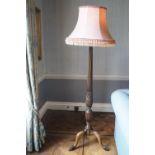 A mahogany standard lamp on cabriole legs with ball and claw feet,