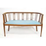 An Edwardian mahogany salon sofa with curved back rail,