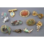 A collection of twenty base metal costume brooches of variable designs.