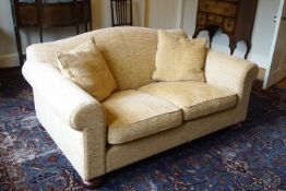 A two seat sofa upholstered in yellow on oak bun feet,