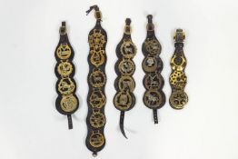 A collection of five leather mounted horse brasses