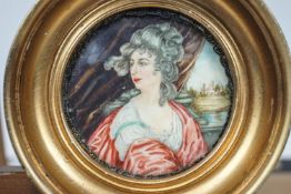 A portrait miniature of a lady sat in a columned arcade looking out to a park with a mansion,