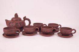 A Chinese red stoneware teapot with six matching cups and saucers,