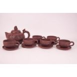 A Chinese red stoneware teapot with six matching cups and saucers,