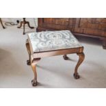 A mahogany stool with drop in seat, on carved cabriole legs, with ball and claw feet,