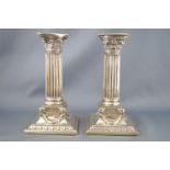 A pair of silver Corinthian candlesticks, of loaded form,
