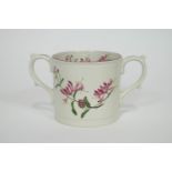 A late 19th century bone china loving cup, decorated with flowering honeysuckle motifs,