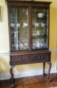 An Edwardian mahogany display cabinet with two glazed doors above two drawers