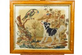 A 19th century framed and glazed Berlin wool work of a dog and a parrot in a landscape,