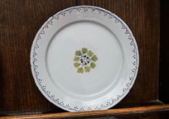 An 18th century English Delft plate, painted with leaves within a lined rim,