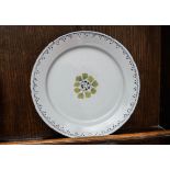 An 18th century English Delft plate, painted with leaves within a lined rim,